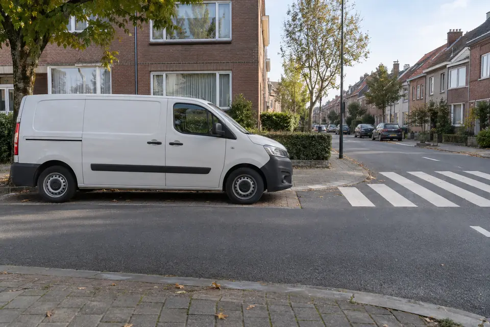 Camionnette blanche arrêtée à proximité immédiate d’un passage pour piétons.