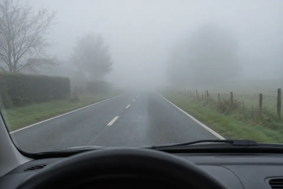 Chaussée à deux sens dont la visibilité est réduite par un brouillard dense.