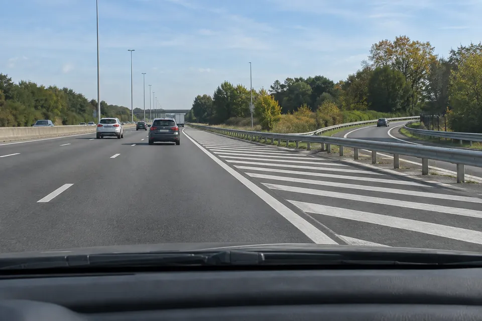 Sortie d’autoroute séparée de la chaussée principale par une zone hachurée et une glissière.