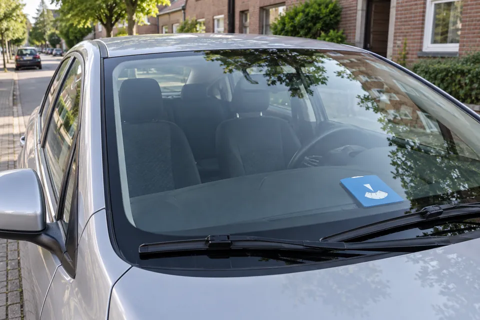 Un disque bleu est posé derrière le pare-brise d’une voiture stationnée.