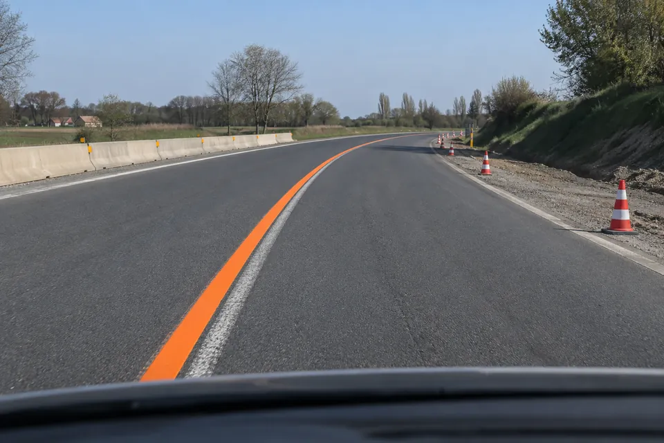 Une ligne orange temporaire recouvre en partie un ancien marquage blanc.